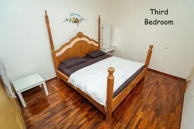 a bedroom with a wooden bed with a wooden floor at GLYSM Tambun Stay in Ipoh
