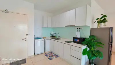 a kitchen with white cabinets and a sink and a refrigerator at Mansion One by Hejmo Suites in George Town