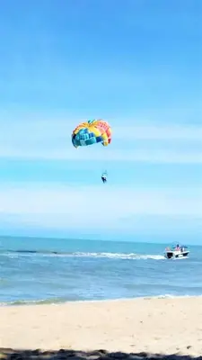 a person is flying a kite on the beach at Partial Seaview with Wifi, Batu Ferringhi in Batu Ferringhi