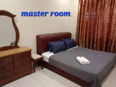 a bedroom with a master room with a bed and a dresser at ARUWDA Homestay in Ipoh