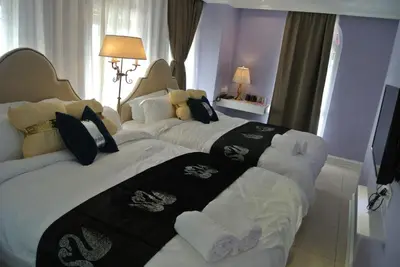 two beds in a hotel room with towels at 1 Day Car Hotel Station 18 in Ipoh