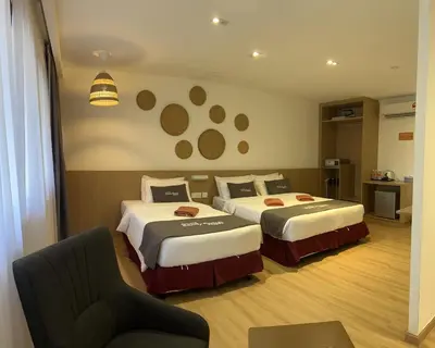 a hotel room with two beds and a chair at Pangkor Sandy Beach Resort in Pangkor