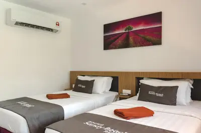 two beds sitting next to each other in a room at Pangkor Sandy Beach Resort in Pangkor