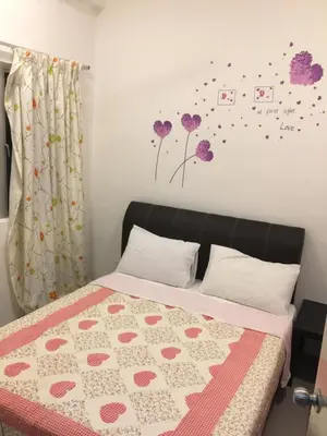 a bedroom with a bed with a pink and white quilt at Cameron DreamWorld Apartment @ Golden Hill in Cameron Highlands