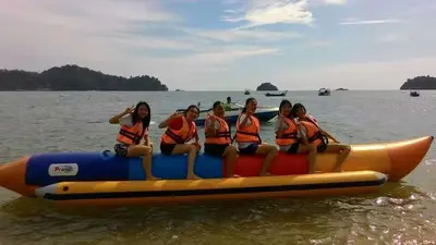 a group of women sitting on a raft in the water at Pangkor Holiday Home in Pangkor