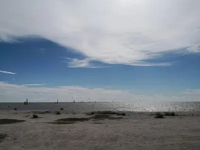 a beach with a cloudy sky and the ocean at The One Boutique Hotel in Sekincan