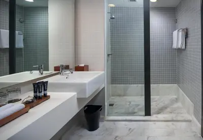 a bathroom with a sink and a shower at G Hotel Gurney in George Town