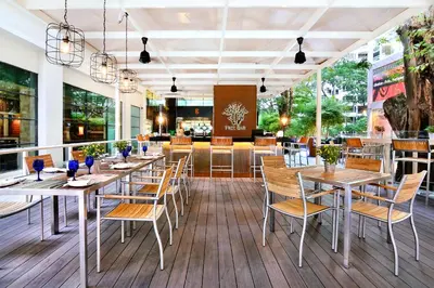 a restaurant with tables and chairs on a deck at G Hotel Gurney in George Town