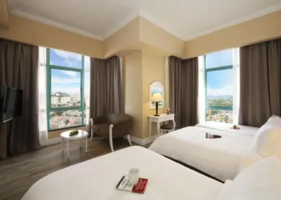 a hotel room with two beds and a large window at Berjaya Penang Hotel in George Town