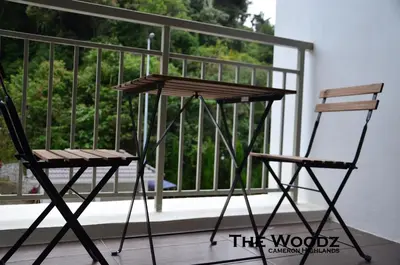two chairs and a table on a balcony at The Woodz Homestay - 3 Bedroom in Cameron Highlands