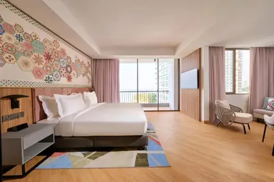 a hotel room with a bed and a desk and a window at M Social Resort Penang in George Town