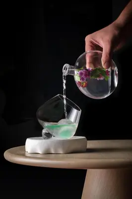 a person pouring a salad into a bowl on a table at M Social Resort Penang in George Town