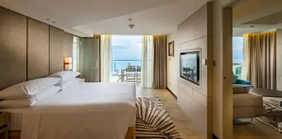 a hotel room with a large bed and a balcony at DoubleTree Resort by Hilton Hotel Penang in Batu Ferringhi