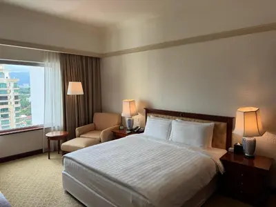 a hotel room with a bed and a chair and a window at Gurney Bay Hotel, A PARKROYAL Partner Hotel in George Town