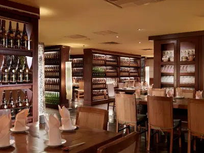 a restaurant with tables and chairs and wine bottles at Cititel Penang in George Town