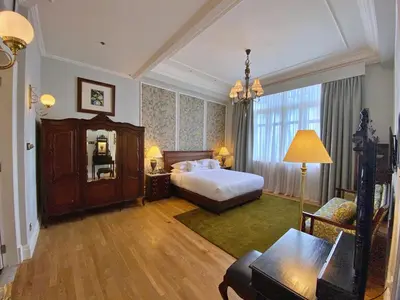 a hotel room with a bed and a couch at Eastern & Oriental Hotel in George Town