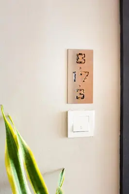 a lightswitch on a wall next to a plant at Octagon Premium Ipoh Town Center by Grab A Stay in Ipoh