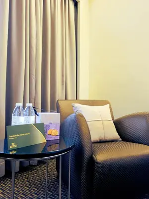 a living room with a chair and a table with a box on it at Sunway Hotel Georgetown Penang in George Town