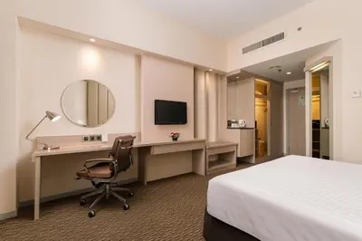a hotel room with a bed and a desk and a mirror at Sunway Hotel Georgetown Penang in George Town