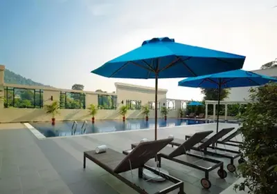 a group of chairs and umbrellas next to a pool at AC Hotel by Marriott Penang in Bayan Lepas