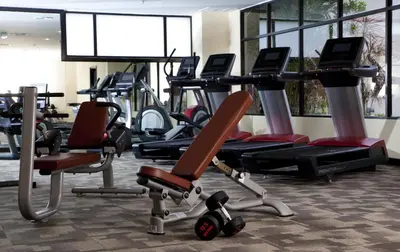 a gym with rows of exercise bikes and treadmills at AC Hotel by Marriott Penang in Bayan Lepas