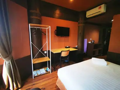 a bedroom with a bed and a desk with a monitor at Regalodge Hotel & Spa Ipoh in Ipoh