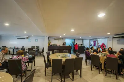 a group of people sitting at tables in a restaurant at YMCA Penang in George Town