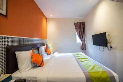 a bedroom with a bed and a tv on the wall at Link Hotel in George Town