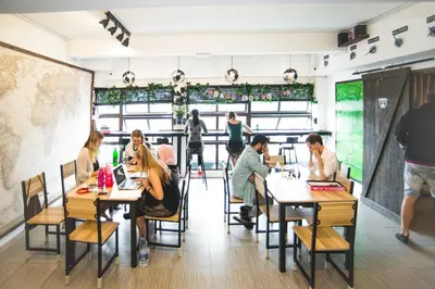 a group of people sitting at tables in a restaurant at Traveller Bunker Hostel in Cameron Highlands