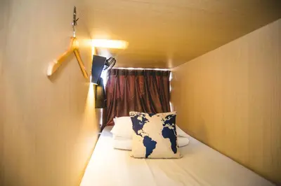 a small room with a bed and a window at Traveller Bunker Hostel in Cameron Highlands