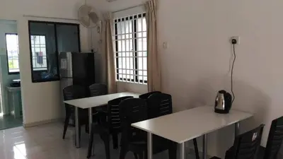 a dining room with two tables and black chairs at J&P Homestays House 1 in Kampar