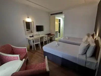 a room with a bed and a couch and a desk at Hotel Seri Malaysia Kulim in Kulim