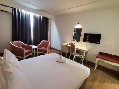 a hotel room with a bed and a desk and a mirror at Hotel Seri Malaysia Kulim in Kulim