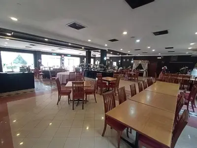 a dining room with tables and chairs and a restaurant at Hotel Seri Malaysia Kulim in Kulim