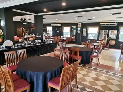 a restaurant with tables and chairs and a bar at Hotel Seri Malaysia Kulim in Kulim
