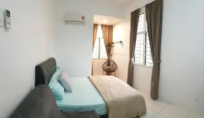 a bedroom with a bed with blue pillows and a window at De Nest Holiday home in Bayan Lepas