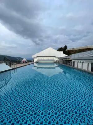 a large swimming pool with blue tiles on a building at Sekata Apartment in Cameron Highlands