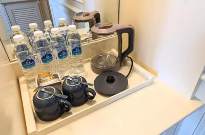 a shelf with bottles of water and a tea kettle at Park Avenue Hotel Sungai Petani in Sungai Petani