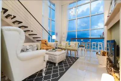 a living room with white furniture and a staircase at Maritime Suite Holiday Rental II in George Town