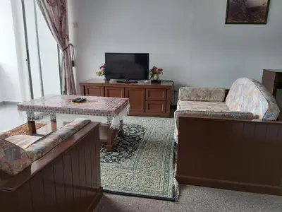 a living room with a couch and a table and a tv at FH Comfy Home in Bukit Fraser