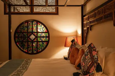 a bedroom with a bed with a stained glass window at Hotel Penaga in George Town