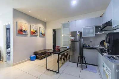 a kitchen with a table and a refrigerator at Sky Suites in George Town