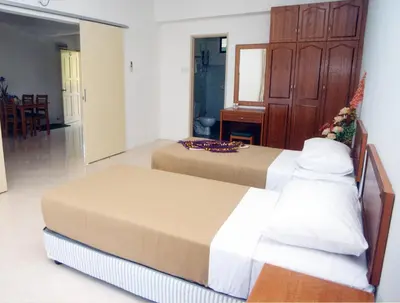 a hotel room with two beds and a mirror at Marina Cove Resort in Lumut