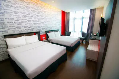 a hotel room with two beds and a tv at INDRA HOTEL - BOUTIQUE SUITES in Ipoh