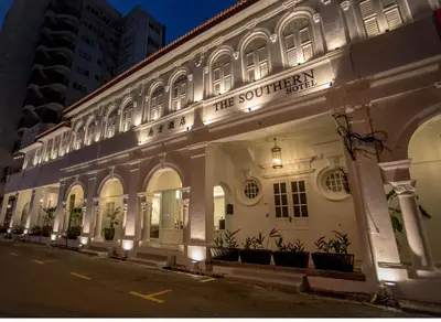 a white building with a sign on the side of it at The Southern Boutique Hotel in George Town