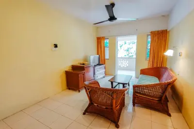 a living room with two chairs and a table at Virgo Batik Resort Teluk Batik Lumut in Lumut