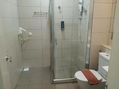 a bathroom with a shower and a toilet at The Octagon Ipoh - Home Stay in Ipoh