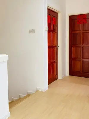 an empty room with two doors and a wooden floor at Shuang Yang Sekinchan Homestay 7 in Sekincan