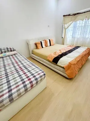 two beds sitting next to each other in a bedroom at Shuang Yang Sekinchan Homestay 7 in Sekincan