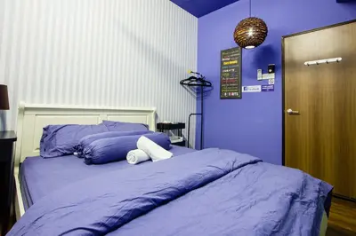 a bedroom with a bed with purple walls at USM Designer Dwell in George Town